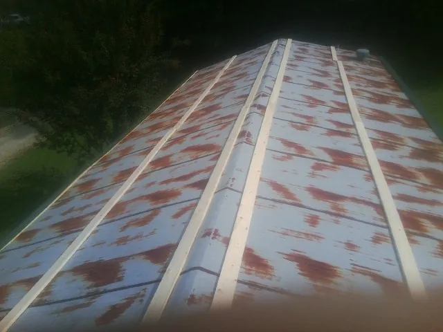 Rusted metal roof panels with new wood purlins before replacement — Storm Damage Roof Repair in Brookville by Roofing Brothers