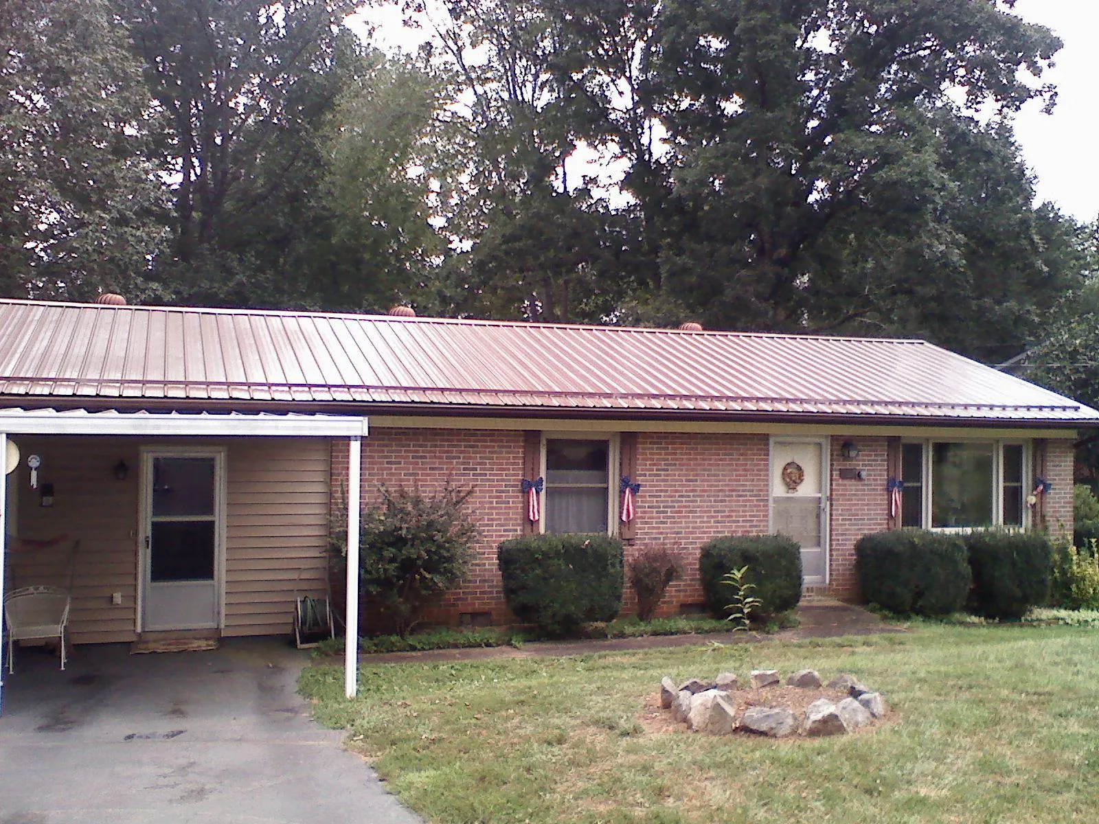 Bronze metal roof and carport on a brick ranch home — Roof Repair work by our crew in Brookville